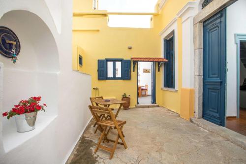a hallway with a table and chairs in a building at Myrsini's House in Symi