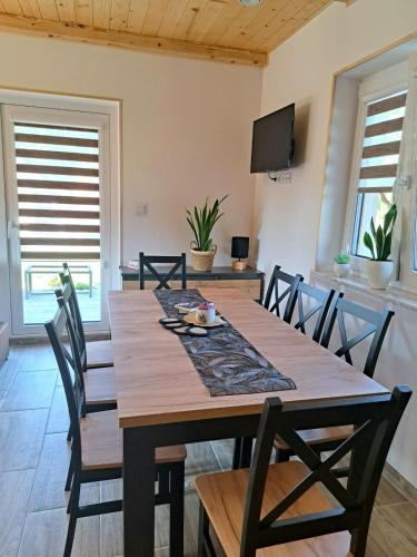 a dining room with a wooden table and chairs at Całoroczne Domki Wypoczynkowe - Osada pod Górą in Ustrzyki Dolne