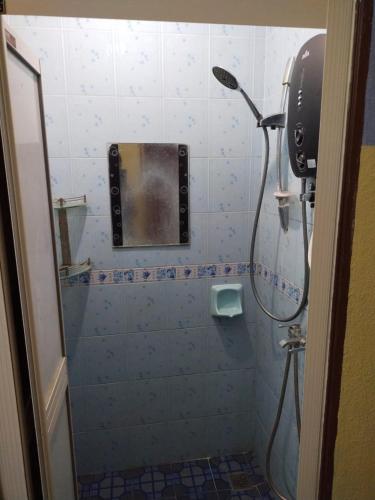 a bathroom with a shower with a mirror on the wall at Semarak Homestay in Baling