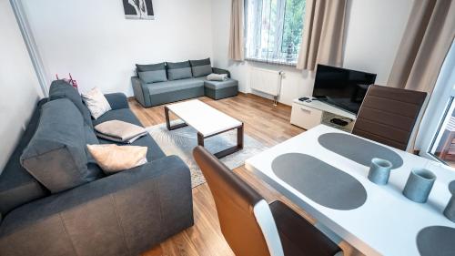 a living room with a couch and a table at Nad Potokiem, Sun & Snow in Krynica Zdrój
