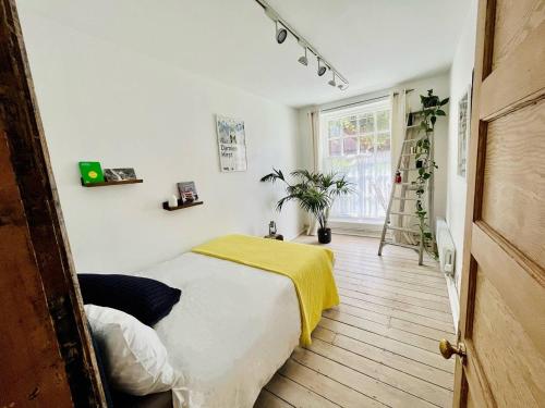 a bedroom with a bed with a yellow blanket on it at Designer Flat in Bethnal Green in London