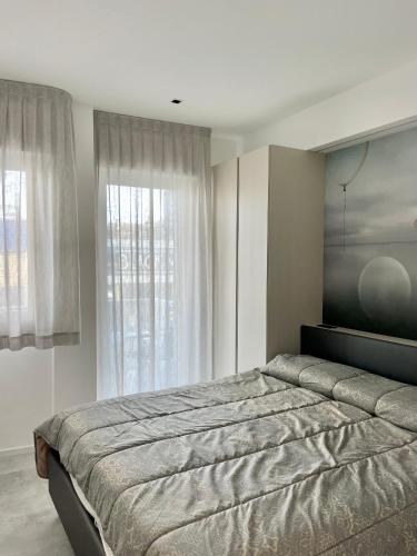 Rondinella Suite في لينانو سابيادورو: غرفة نوم بسرير ونافذة كبيرة