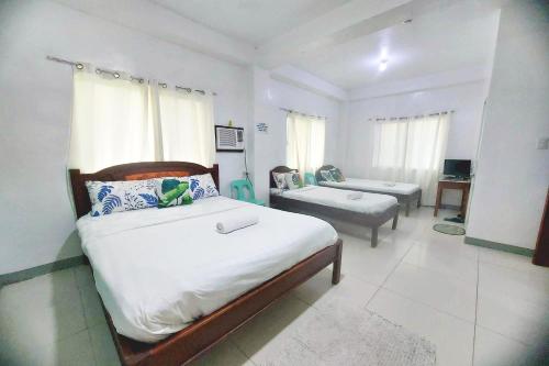 a bedroom with a bed and a couch in it at Charlz Angel Inn in Iloilo City