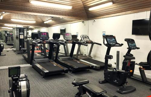 a gym with a bunch of tread machines in it at Glynhill Hotel & Spa near Glasgow Airport in Paisley