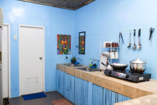 cocina con paredes azules y encimera con fogones en Nasigdan Serene Homestay, en El Nido