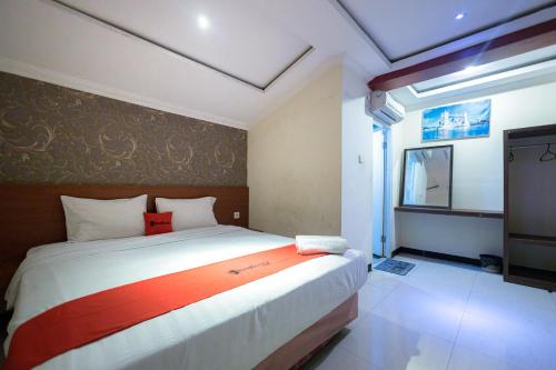 een slaapkamer met een groot bed en een televisie bij RedDoorz At Kutisari Surabaya in Surabaya