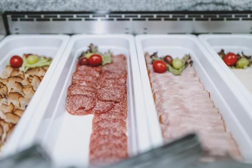 a row of plastic trays filled with meats and vegetables at Hotel DIE SONNE in Saalbach Hinterglemm
