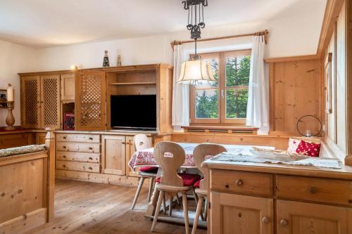 a kitchen with wooden cabinets and a table and chairs at Apartment Funtnatsch in Laion