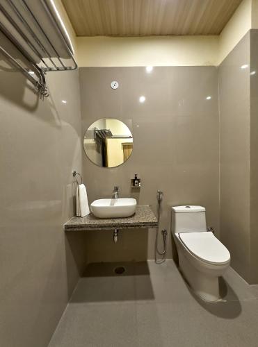 a bathroom with a toilet and a sink and a mirror at Ranthambhore Uday Vilas in Sawāi Mādhopur