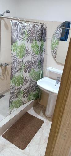 a bathroom with a shower curtain with a toilet and a sink at Luxurious Apartment Center Agdal Rabat in Rabat