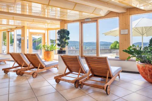 a row of chairs in a room with windows at Hotel Vier Jahreszeiten am Schluchsee in Schluchsee