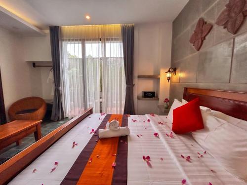 a bedroom with a large bed with roses on it at The Palmery in Siem Reap