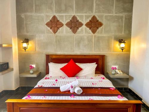 a bedroom with a bed with red pillows at The Palmery in Siem Reap