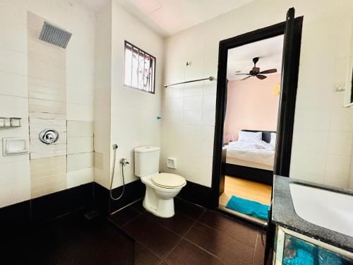 a bathroom with a toilet and a sink and a bed at FamilyHaven at Presint 18 by Elitestay [5Rooms] in Putrajaya