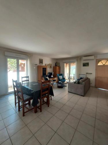 un grand salon avec une table et des chaises dans l'établissement Sainte Marie la mer : Villa indépendante, plage à pied à 250 m, à Sainte-Marie-la-Mer
