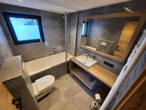 a bathroom with a toilet and a sink and a tub at Ferienhaus Anna in Sölden