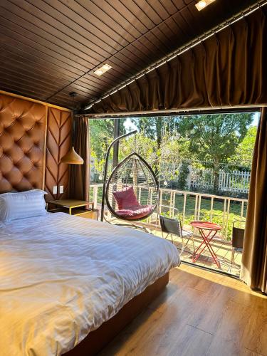 a bedroom with a bed and a balcony with a swing at Mongo Garden in Da Lat