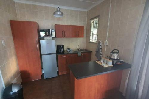 a kitchen with a refrigerator and a counter top at Stay at the Ridge in Bloemfontein