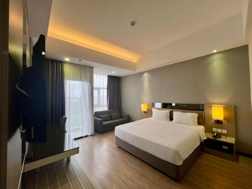 a large bedroom with a bed and a couch at Livingston Hotel in Sandakan