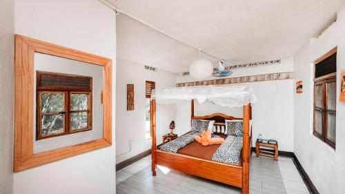 a bedroom with a wooden bed and a window at Mama Washindi Lodge in Pakwach East