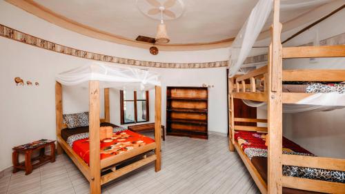 a bedroom with two bunk beds and a mirror at Mama Washindi Lodge in Pakwach East