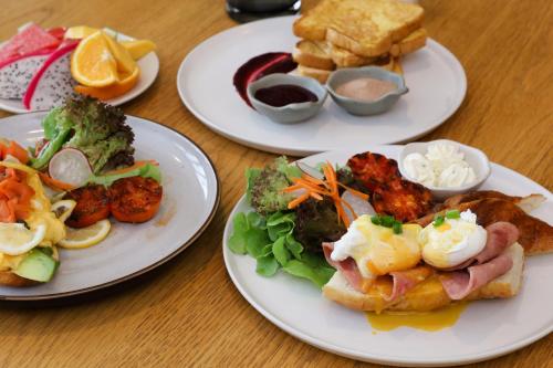 three plates of food on a wooden table at The Rise Suites Hotel, Chiang Mai - SHA Extra Plus in Chiang Mai