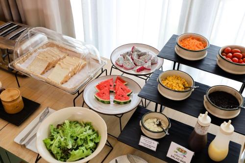 a table filled with different types of food on plates at The Rise Suites Hotel, Chiang Mai - SHA Extra Plus in Chiang Mai