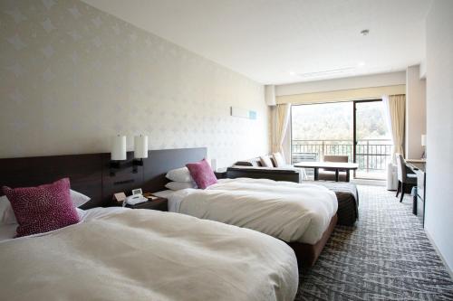 a hotel room with two beds and a living room at Hotel Harvest Kinugawa in Nikko