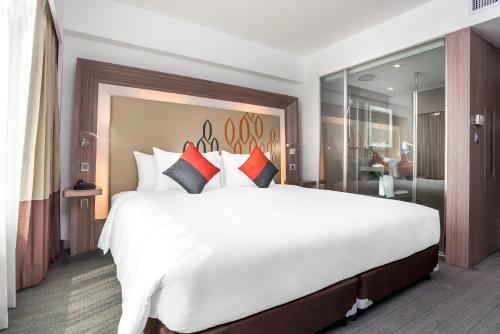 a large bedroom with a large white bed with pillows at Hilton Garden Inn Bangkok Silom in Bangkok