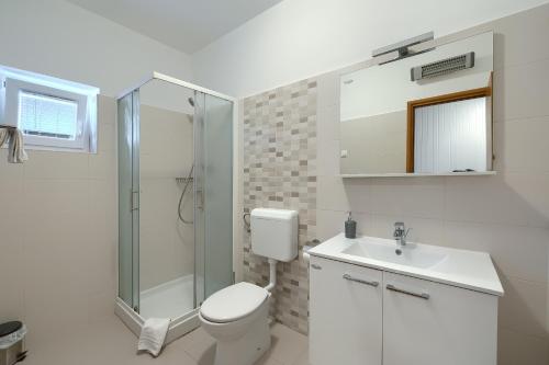 a bathroom with a toilet and a shower and a sink at Villa Parlera in Ližnjan