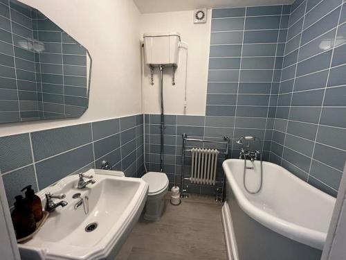 uma casa de banho com um lavatório, uma banheira e um WC. em Luxury Penthouse Apartment em Lowestoft