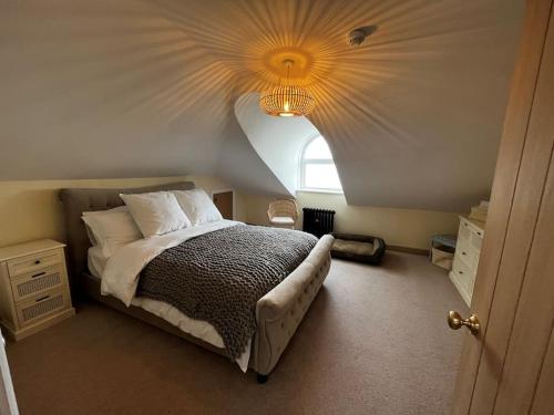 a bedroom with a large bed with a chandelier at Luxury Penthouse Apartment in Lowestoft