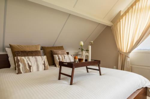 ein Schlafzimmer mit einem Bett und einem Tisch darauf in der Unterkunft B&B Giethoorn in Giethoorn