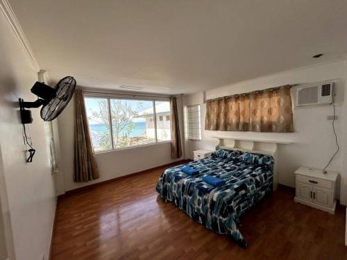 バウアンにあるBobby's Villa Beachfront, Bauangのベッドルーム1室(ベッド1台、大きな窓付)