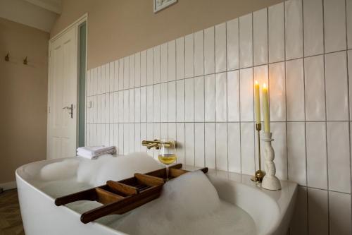 a bath tub with a candle in a bathroom at B&B Giethoorn in Giethoorn