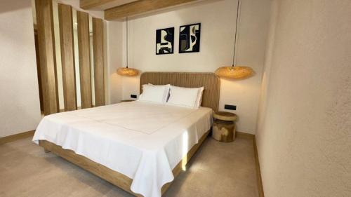 um quarto com uma cama branca e 2 candeeiros em Club Kavala Beach Hotel Assos em Behramkale