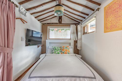 uma cama num pequeno quarto com uma janela em And spring em Jeonju