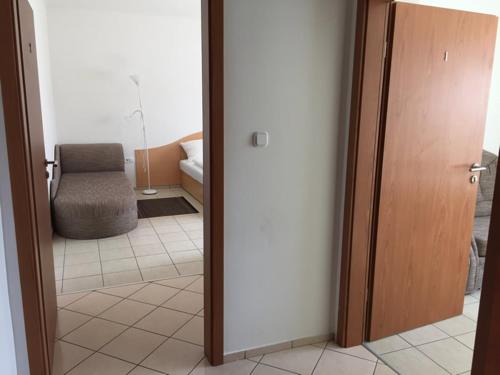 a room with a door and a chair in a room at Lamar Apartman in Kapuvár