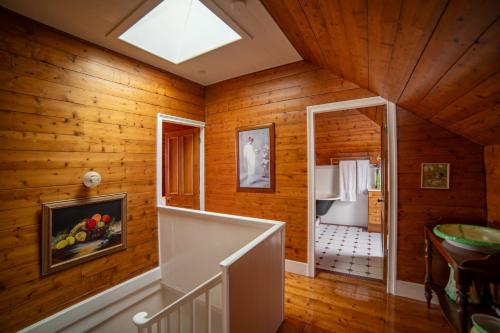 Una habitación con paredes de madera y una escalera en una casa en Poet's Cottage Stanley, en Stanley