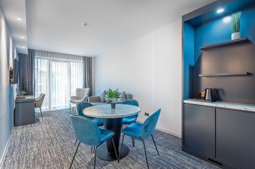 a room with a table and chairs and a kitchen at Ramada by Wyndham Tbilisi Old City in Tbilisi City