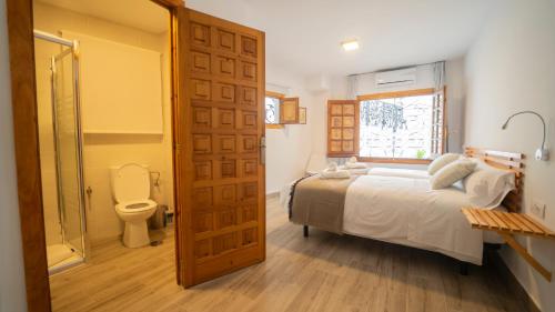 a bedroom with a bed and a bathroom with a toilet at Carmen San Luis Albaicin, Granada in Granada