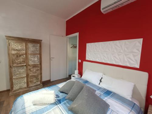 een slaapkamer met een rode muur en een bed bij Lovely Apartment Piatti Duomo in Milaan