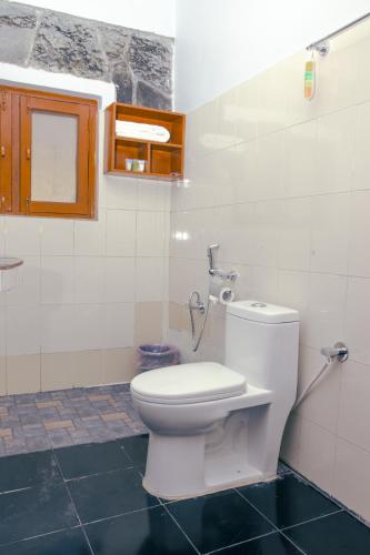 a bathroom with a white toilet in a room at Roamers Inn in Pokhara