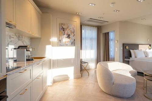 a kitchen and a bedroom with a bed and a chair at The Villa by Frogner House in Stavanger