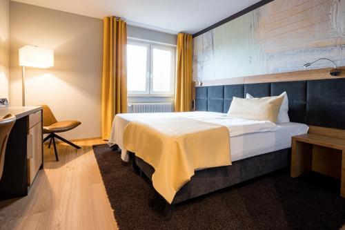 a hotel room with a large bed and a window at laVital Sport- & Wellness Hotel in Wesendorf