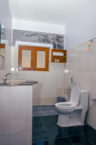 a bathroom with a toilet and a sink at Roamers Inn in Pokhara
