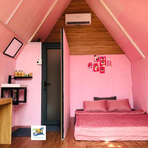 a pink bedroom with a bed in a room at Cóc Retreat Mỹ Tho City in My Tho
