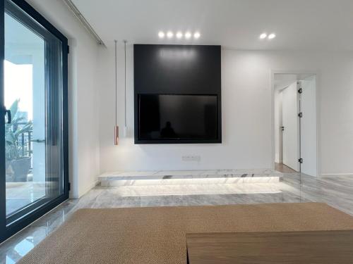 a living room with a flat screen tv on a wall at Shanghai Jing'an Art Pavilion-Large 3Bedrooms South-north Direct Sunny House in Shanghai