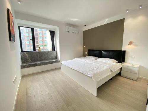 a bedroom with a large white bed and a window at Shanghai Jing'an Temple Quality 3 bedrooms Alarming and quiet Commercial area Convenient transportation in Shanghai