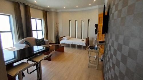 a living room with a room with a bed and a table at Castellon Boutique Hotel in Table View